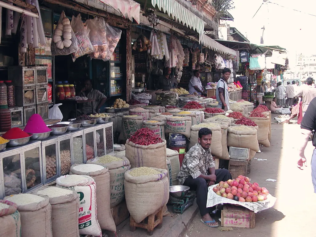 Sacks of grain, spices and produce lining a busy market street in Bangalore