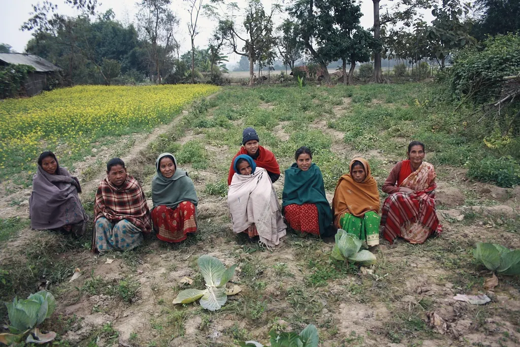Women farmers seated together in a field during a community meeting in Nepal’s Terai